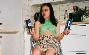 Young woman holding two cans of beer