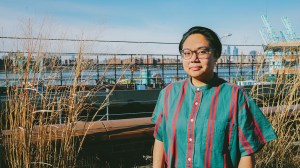 Image of Filipino American Non-Binary Person in front of the Manhattan skyline.