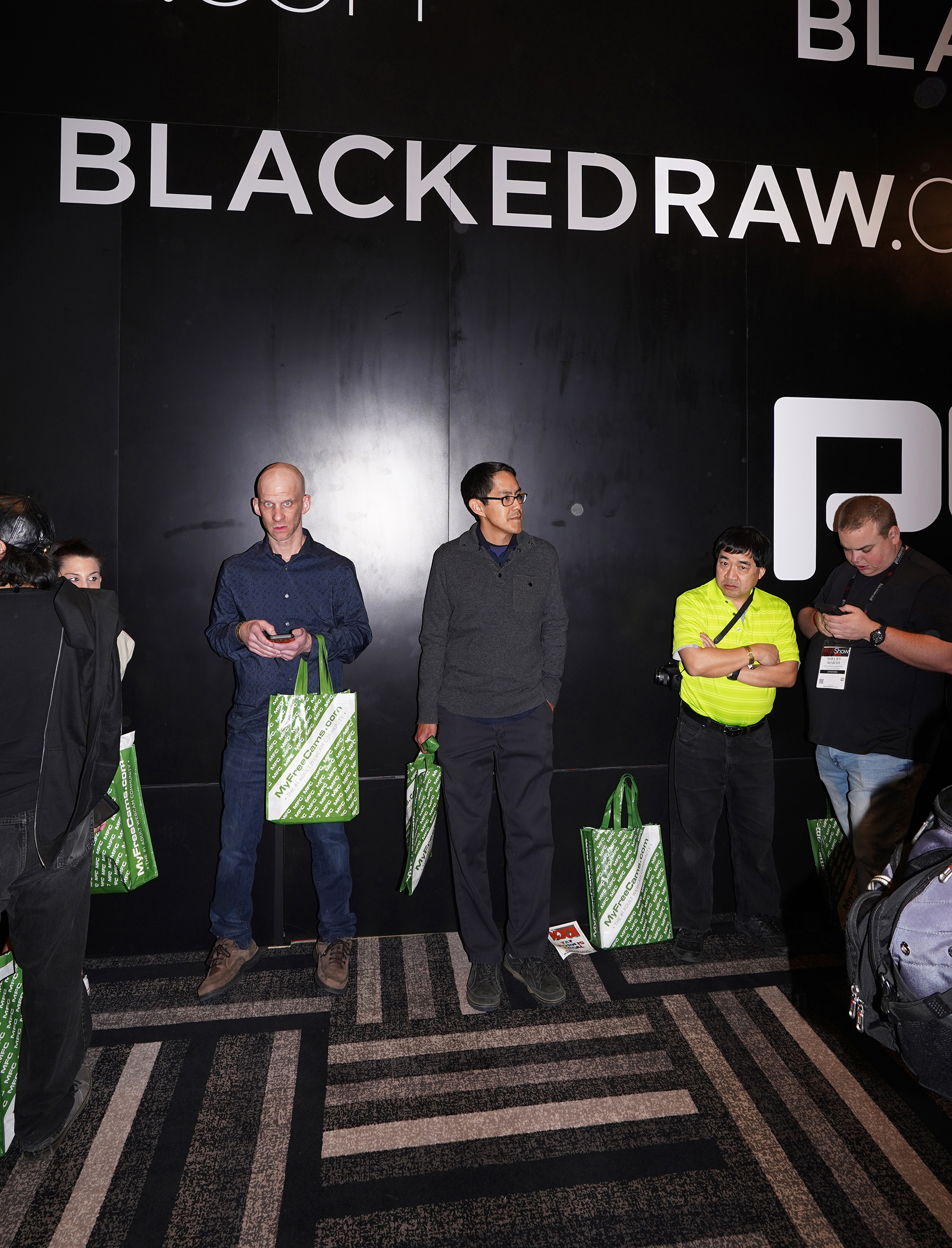 A group of porn fans lining up under an advertisement for BlackedRaw