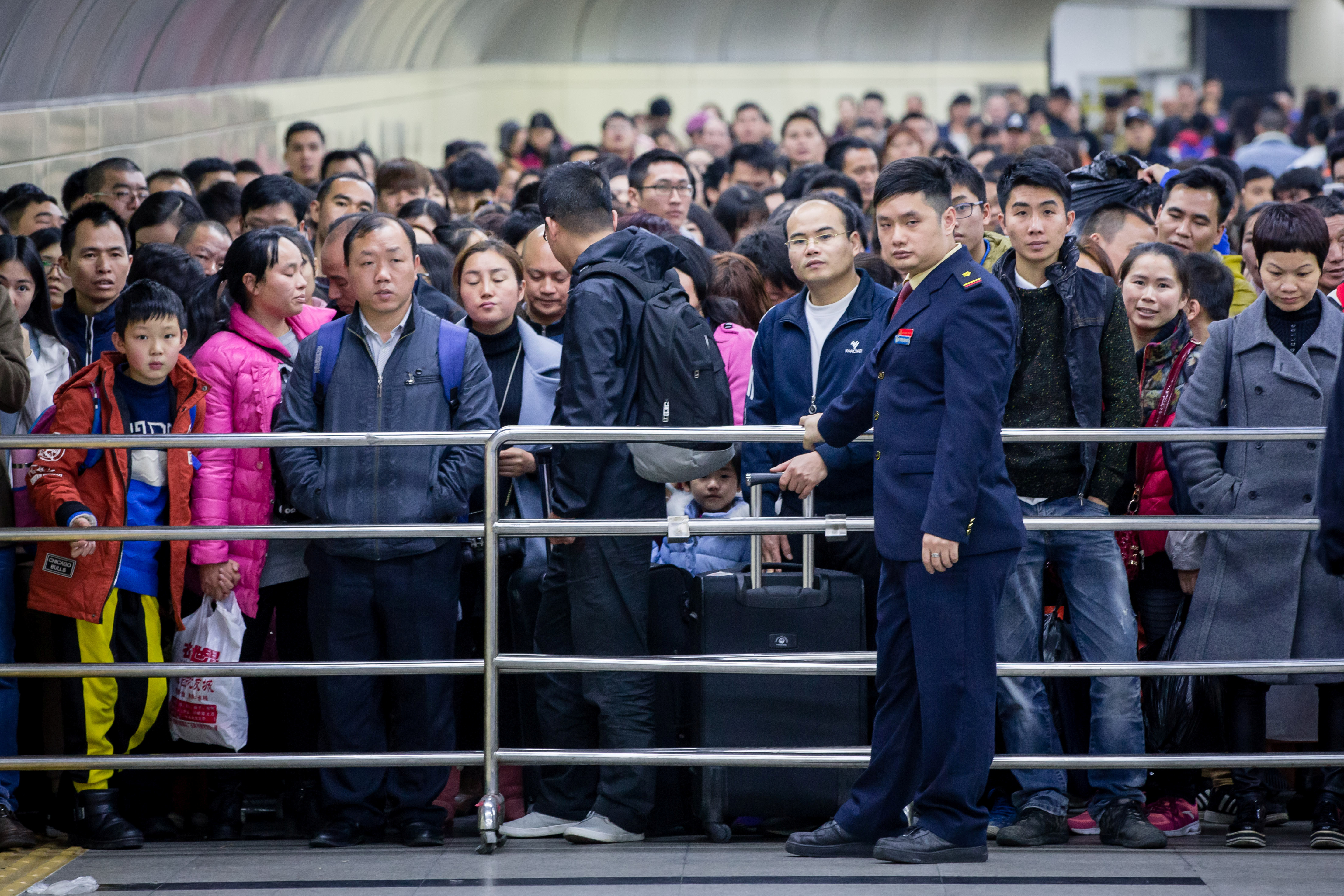 Passengers wait to enter a railway station during the annual Spring Festival travel rush. Image via Reuters