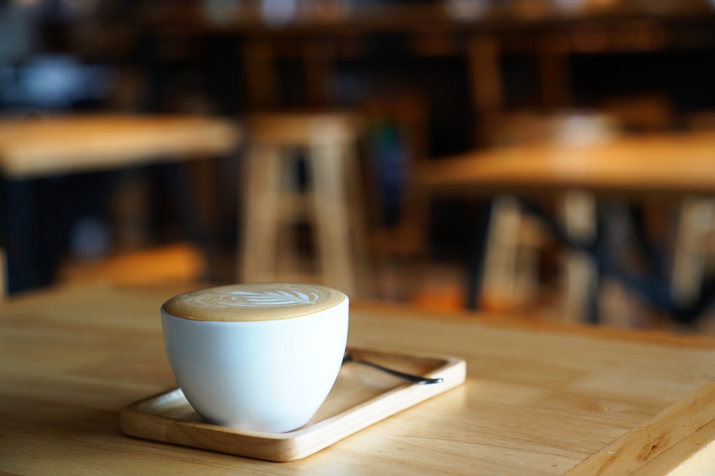 a cup of coffee on a wooden table