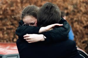 A girl embracing an adult outside Dunblane primary school in 1996