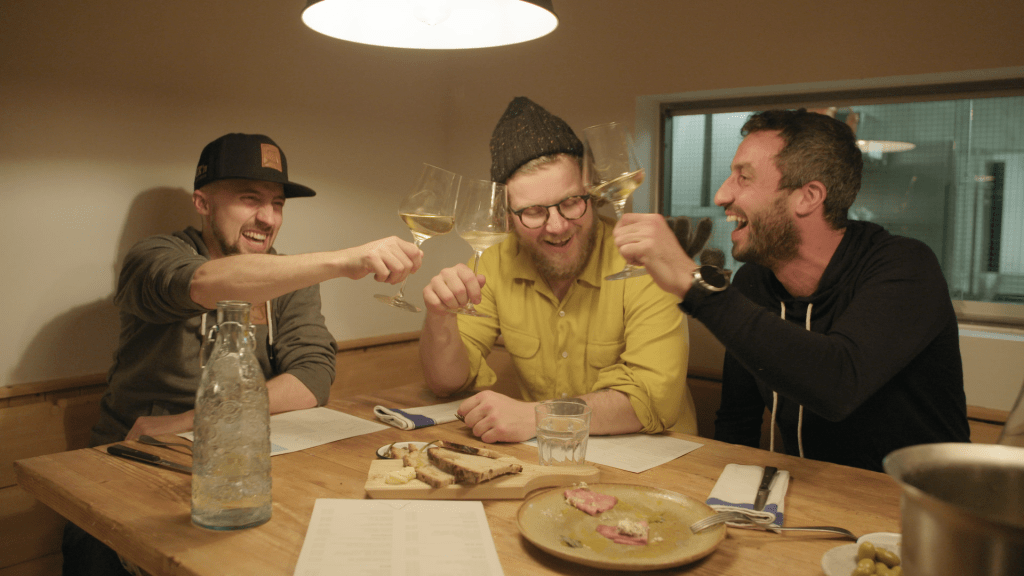 Markus Kössler und seine Freunde stossen im Restaurant Aroleid Kollektive mit Wein an