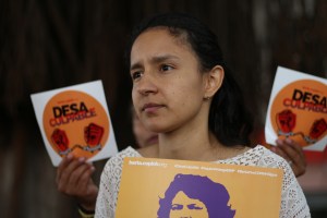 Bertha Zúniga​ holding a poster of her mother, Berta Cáceres