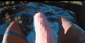 A man's legs with a pixelated dildo between them.