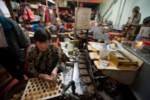 Nancy Chan makes fortune cookie at Golden Gate Fortune Cookie Factory in San Francisco's China Town