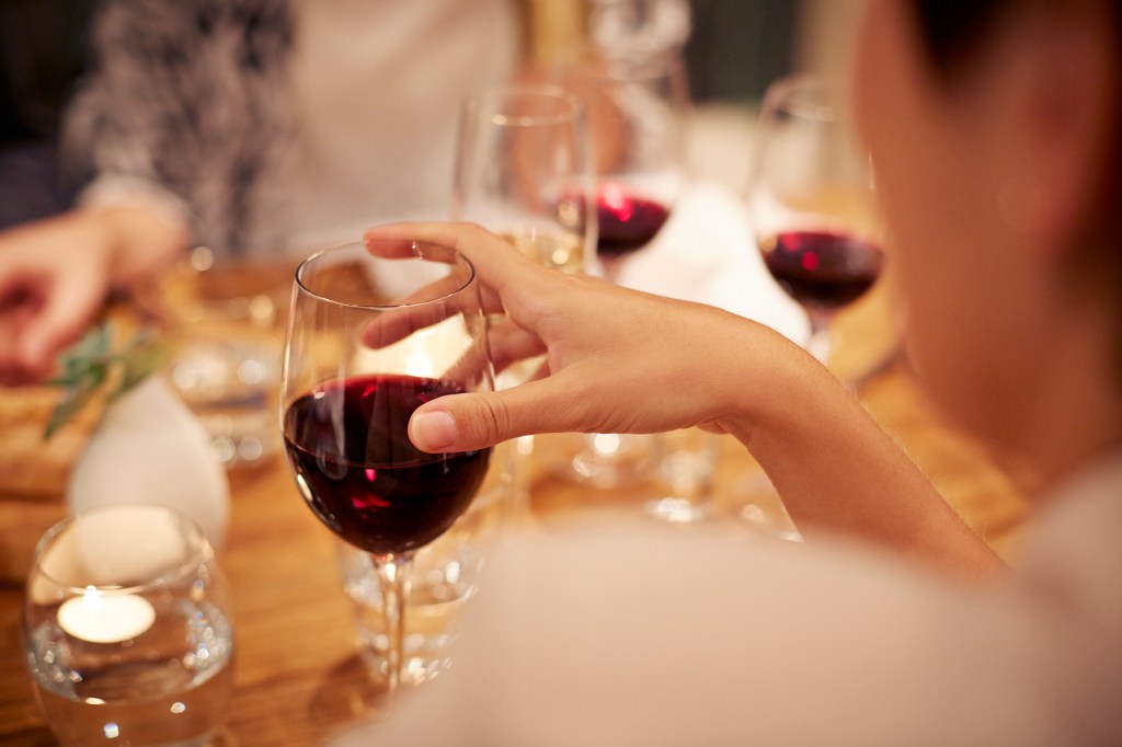 hand holding a glass of red wine