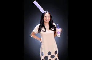 woman dressed up like a bubble milk tea and holding a cup of milk tea