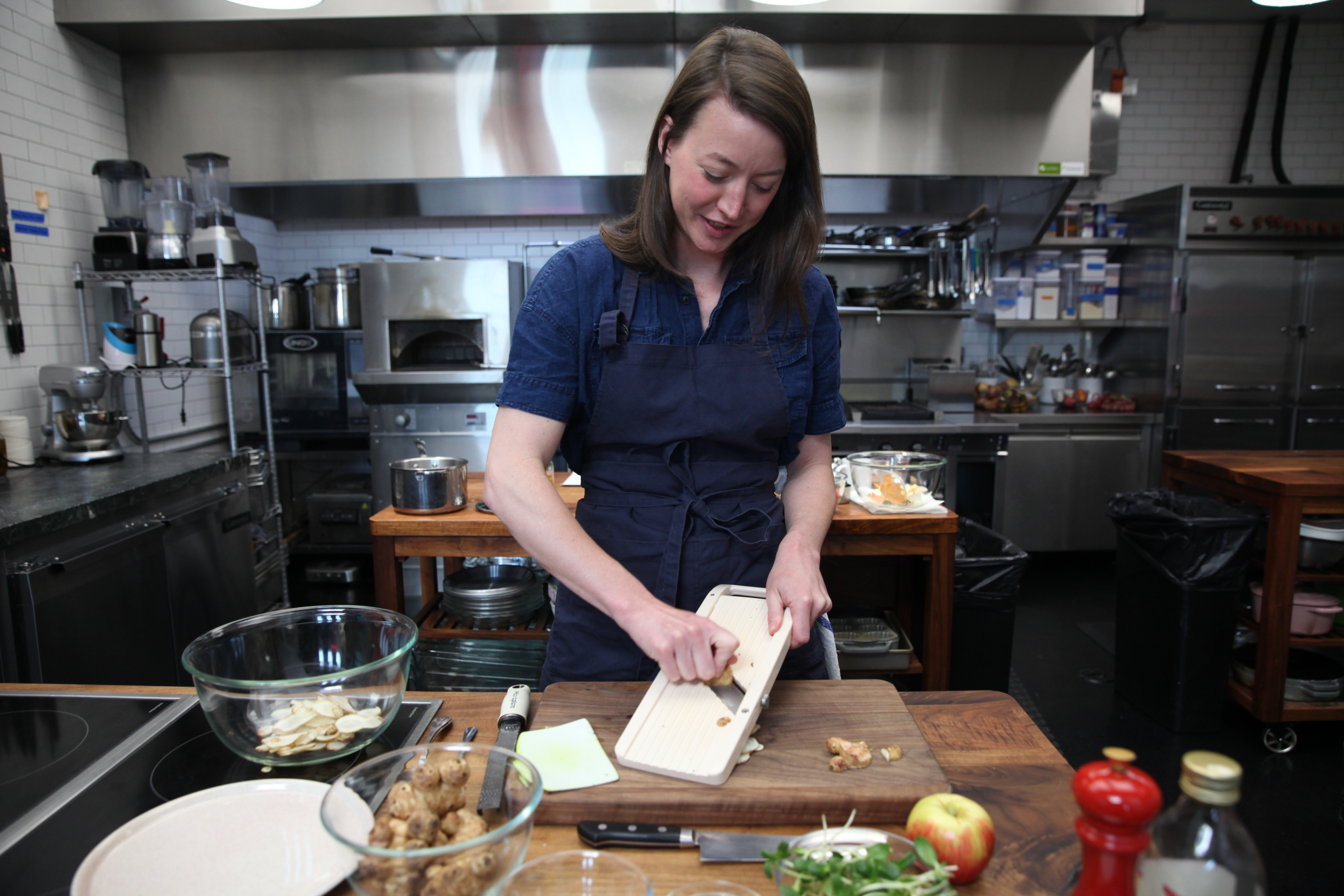 chef julia sullivan of henrietta red slicing sunchokes on a mandoline