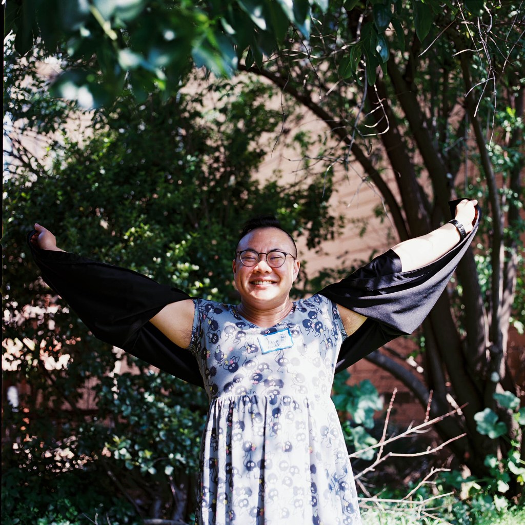 a person attending the ugly conference spreads their arms and smiles