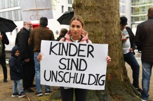 Nadja Zagarti hält ein Plakat mit der Aufschrift "Kinder sind unschuldig"