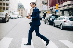 Man crossing the street with a phone