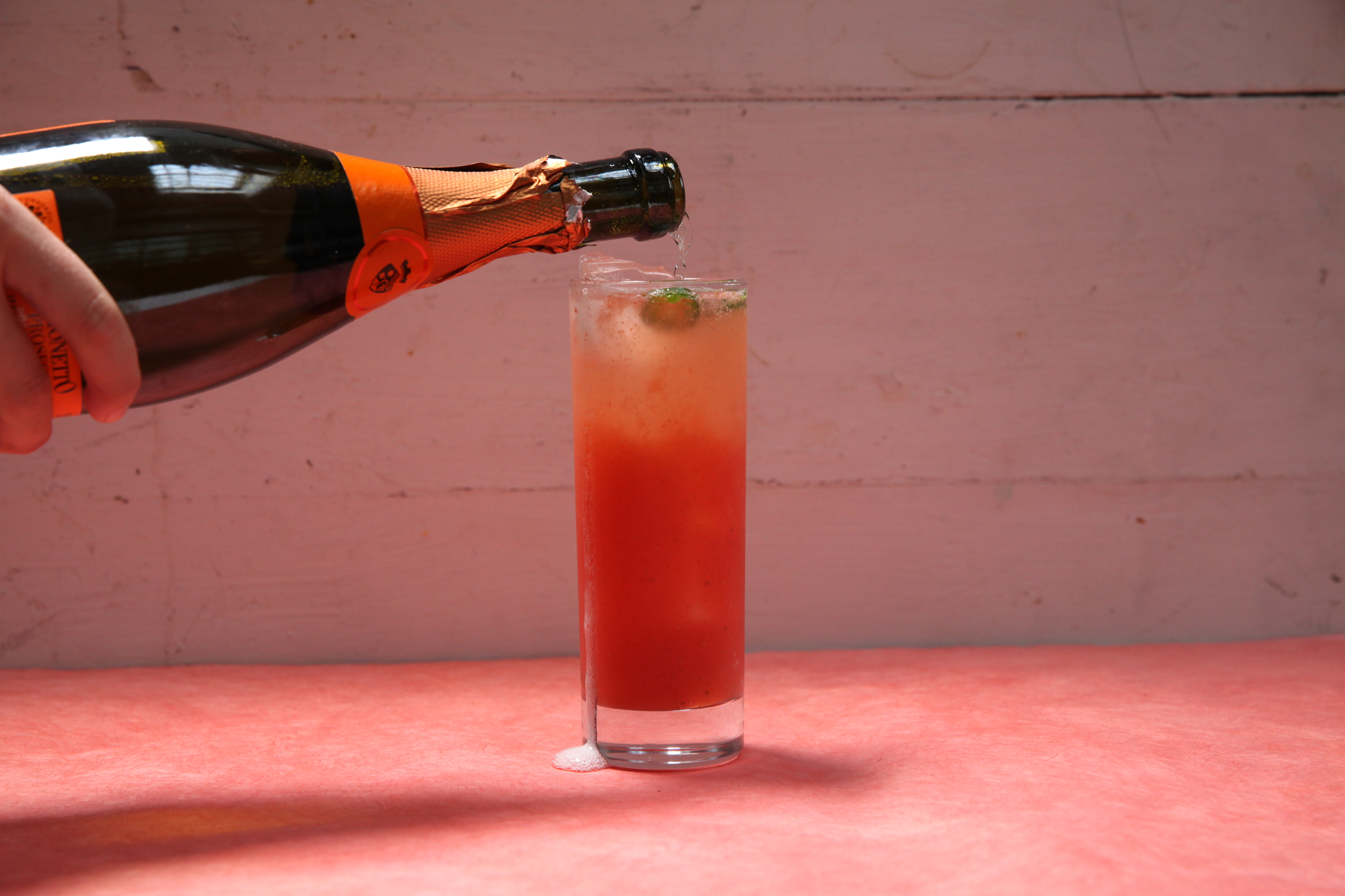 chef janine booth topping up a rhubarb cocktail with prosecco