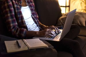 Young man sitting on couch with laptop