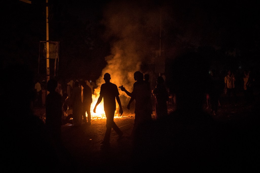 Protesters walk in front of a burning tire at the barricades on Nile Street in Khartoum where security forces attacked them on May 13 2019