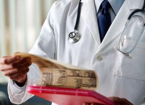 Doctor in white coat checking red clipboard