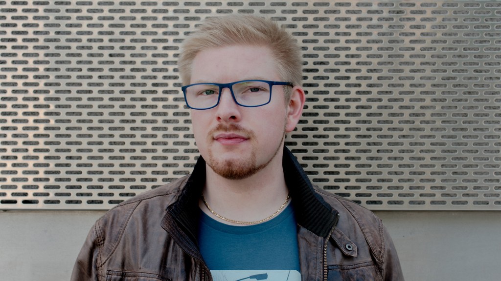 Ein blonder, polyamorer Mann mit Brille