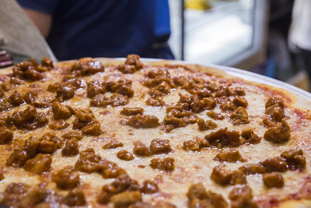 a meat-topped pizza from rosario's pizza in brooklyn