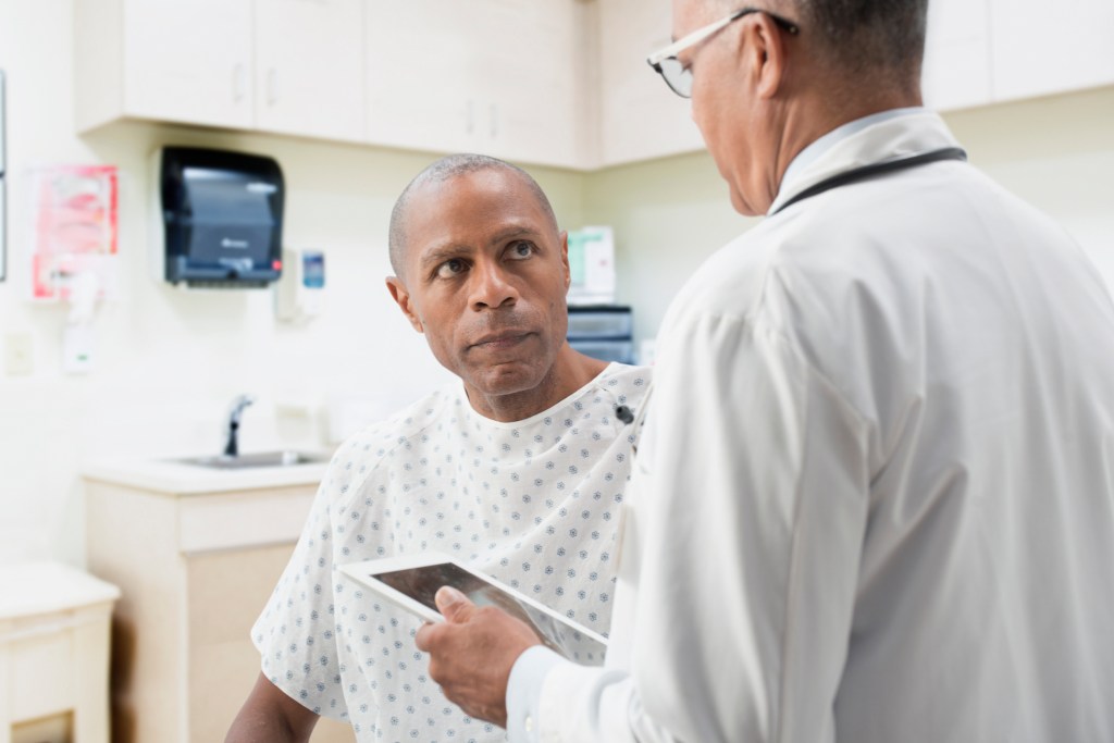 white male doctor talking to black male patient