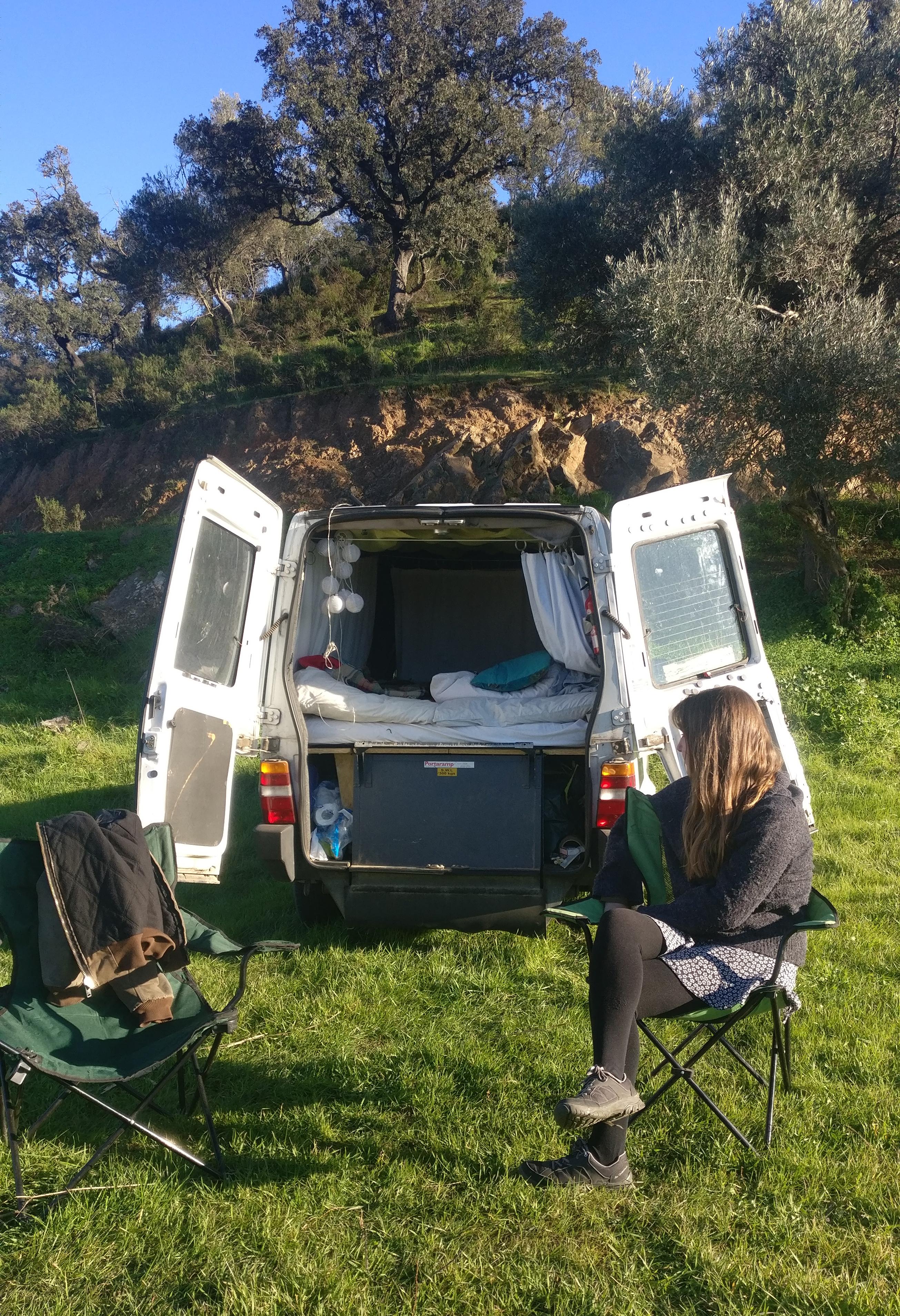 Woman sitting outside a van