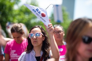 A pro-choice demonstrator holds a coat hanger at a rally