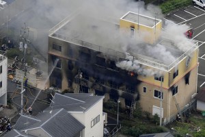 An aerial view shows firefighters battling fires at the site where a man started a fire after spraying a liquid at a three-story studio of Kyoto Animation Co. in Kyoto