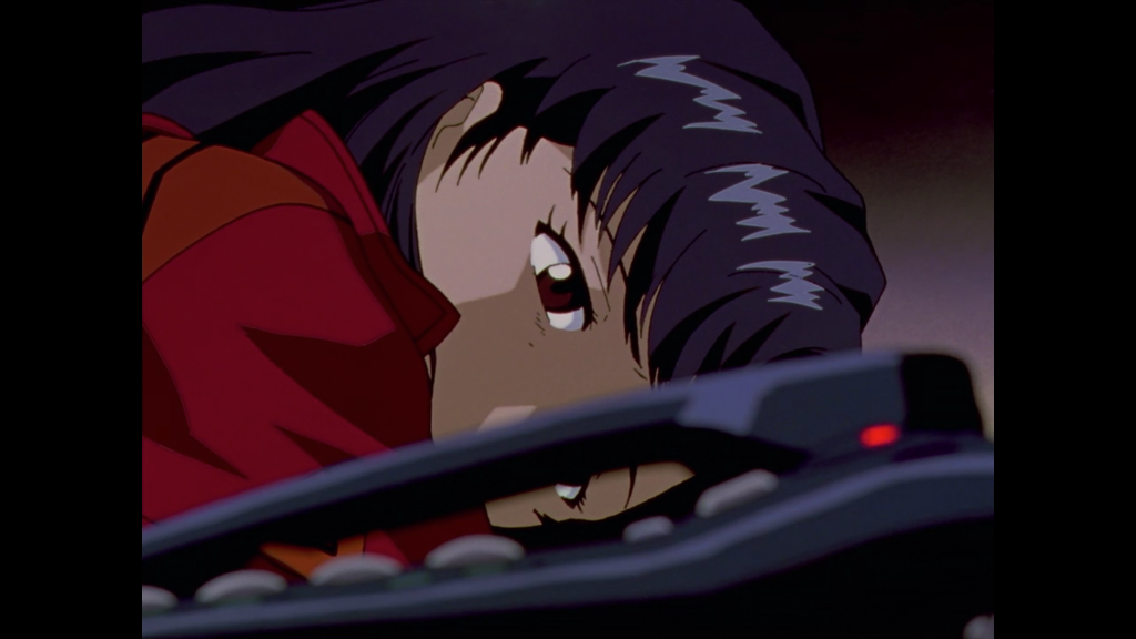 Screenshot from Neon Genesis Evangelion, Misato, struck with grief, lays on her desk and turns her head to look at her phone