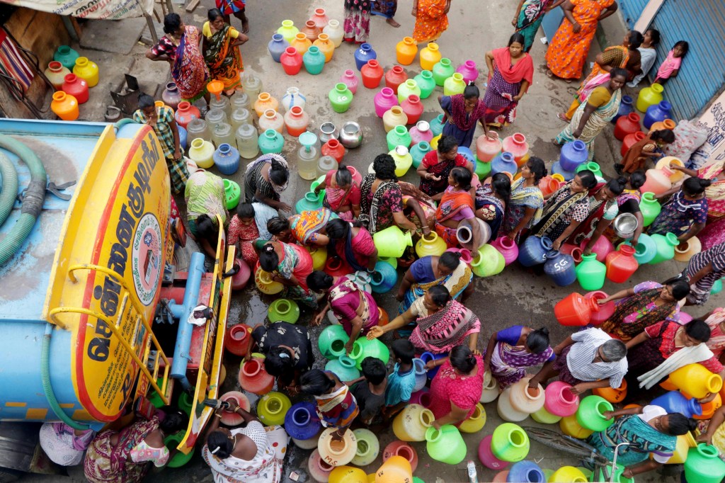 Indians stand in line to fill water jugs.