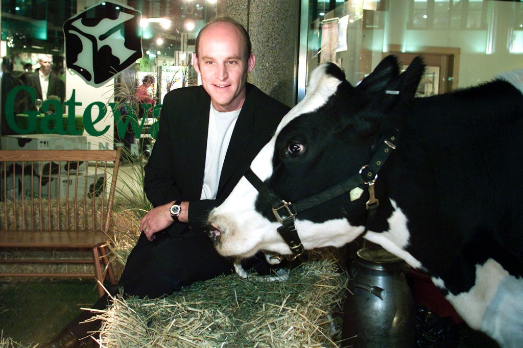 CEO of Gateway Computers sits with a cow