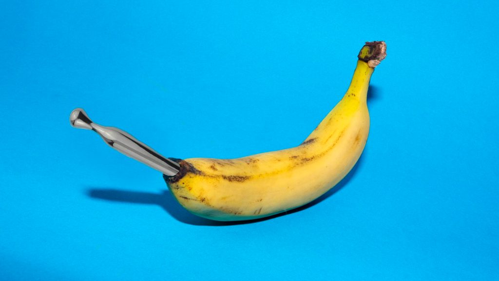 Eine Banane, in der ein silberner Stift steckt