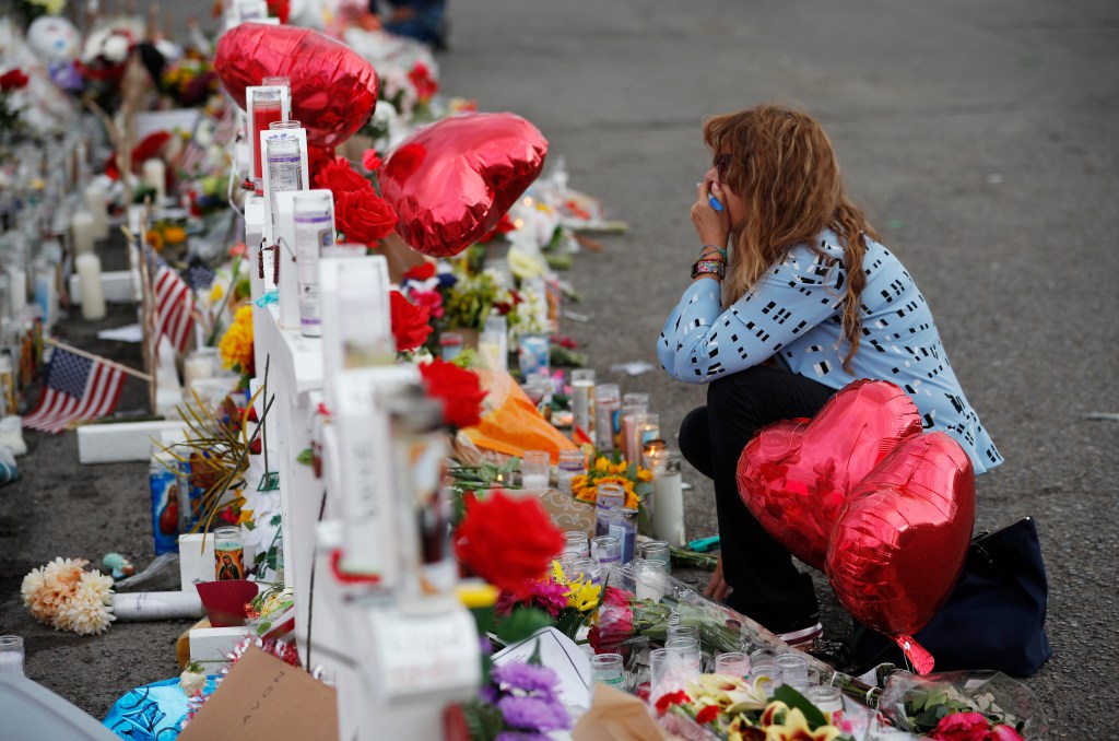 AP_19218518631393Gloria Garces kneels in front of crosses at a makeshift memorial near the scene of a mass shooting at a shopping complex Tuesday, Aug. 6, 2019, in El Paso, Texas.