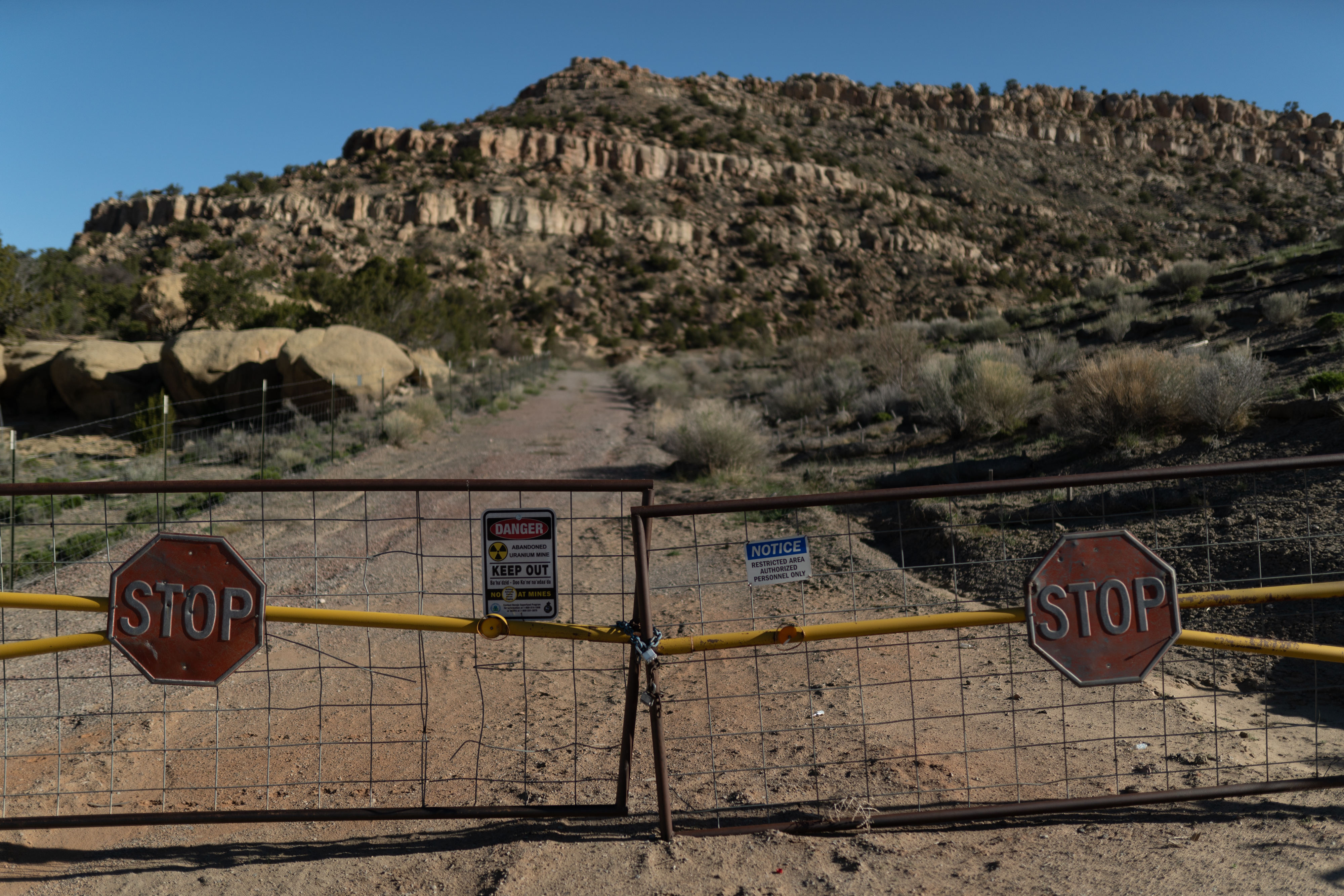 A desert road blocked by a warning sign