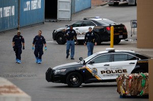 Police officers walk behind a Walmart at the scene of a mass shooting at a shopping complex Tuesday, Aug. 6, 2019, in El Paso, Texas.