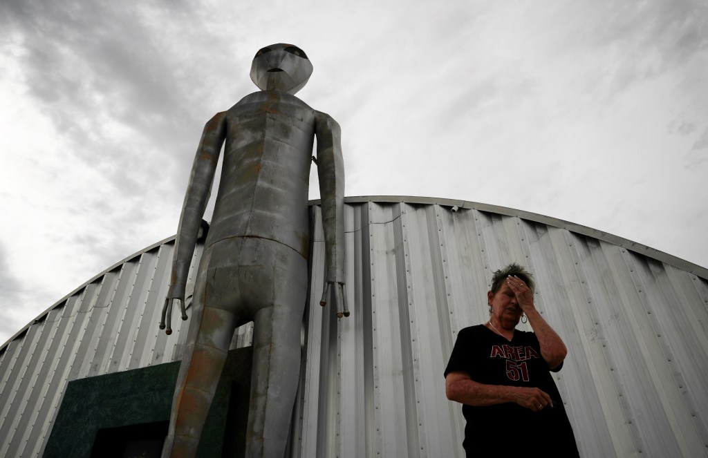 In this July 22, 2019 file photo, Linda Looney wipes her face outside of the Alien Research Center, a gift shop on the Extraterrestrial Highway, in Crystal Springs, Nev. (AP Photo/John Locher, File)​