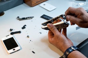 Two hands taking apart electronics