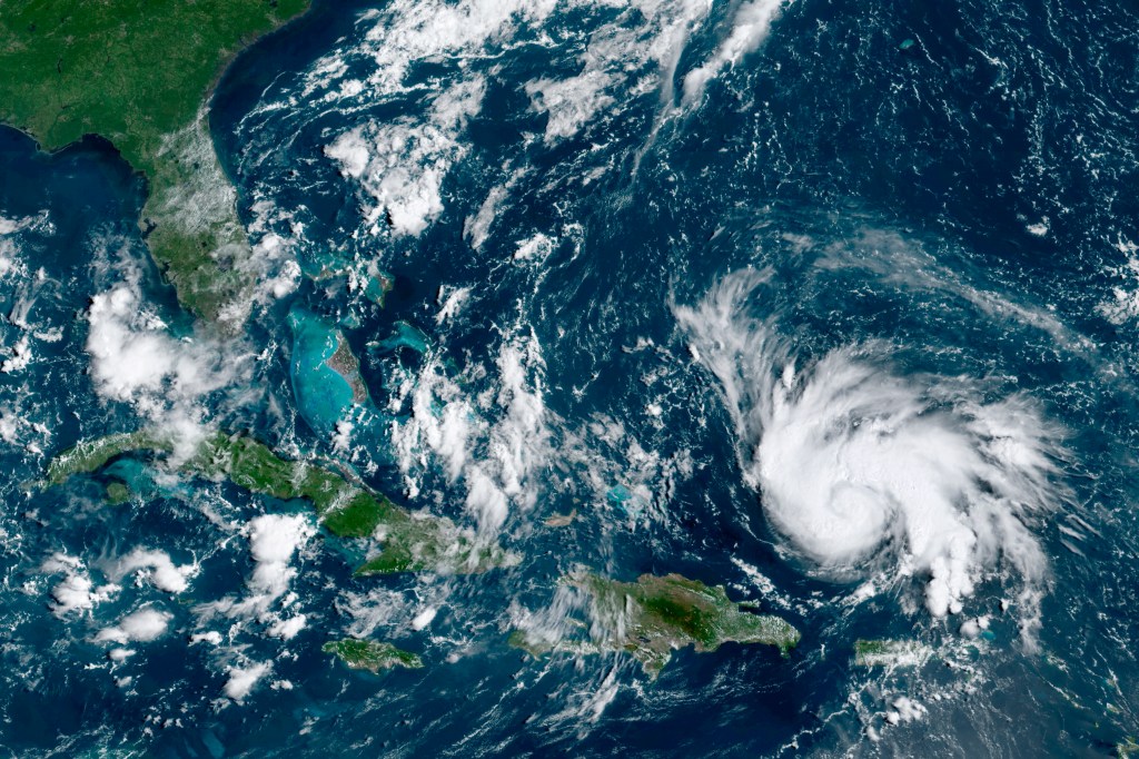 This GOES-16 satellite image taken Thursday, Aug. 29, 2019, at 14:20 UTC and provided by National Oceanic and Atmospheric Administration (NOAA), shows Hurricane Dorian, right, moving over open waters of the Atlantic Ocean. (NOAA via AP)​