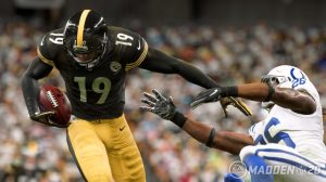 A screenshot from Madden 20, two football players, one running with the ball pushing past another who is falling over