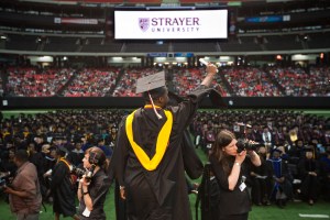 A Black student celebrates at a commencement ceremony.