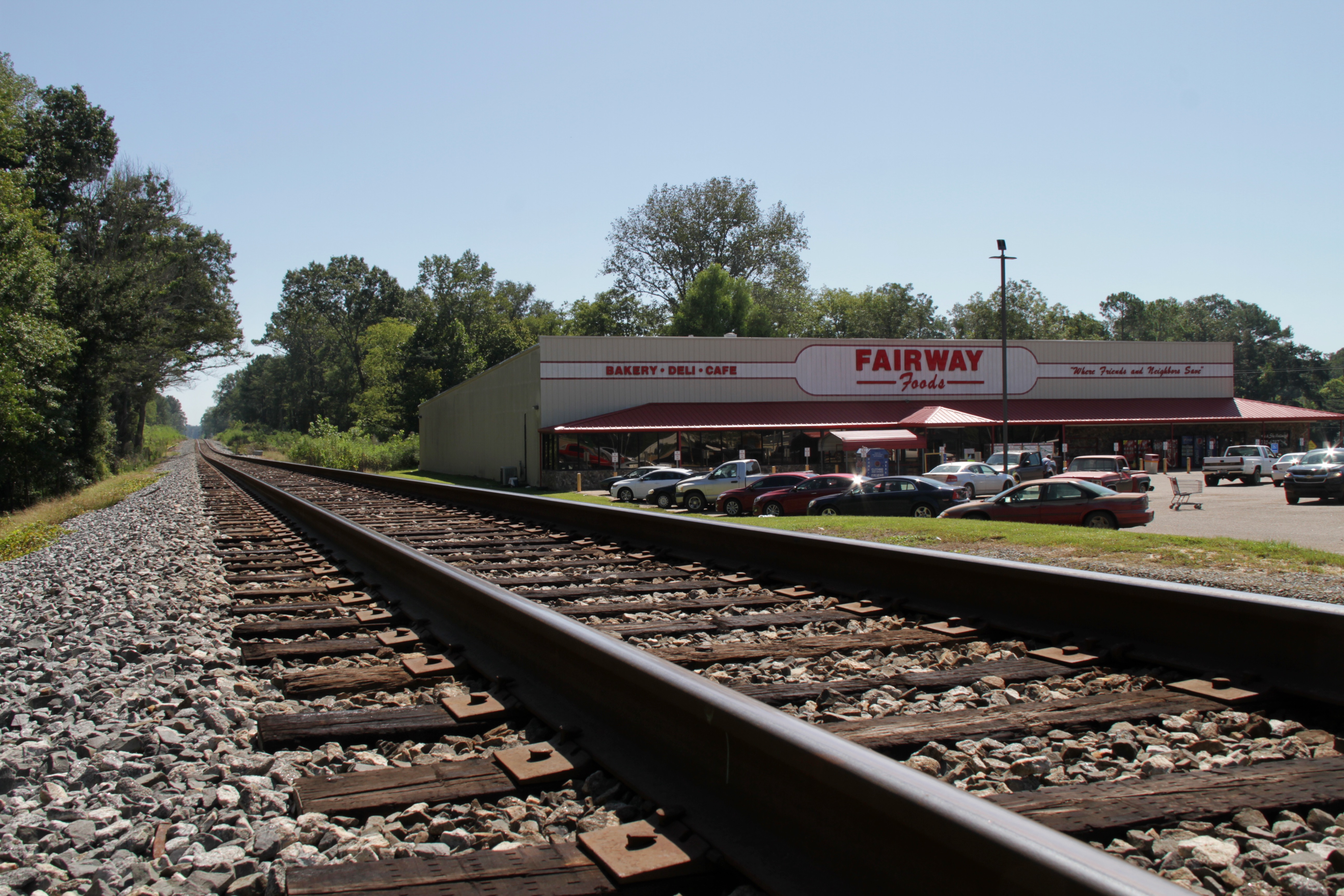 A grocery store next to train tracks.