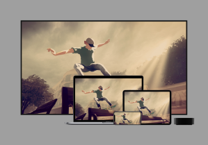 Image of a TV, A macbook, an iPad, and an iPhone, all with the same image of a video game on it. A white man wearing a green shirt and blue jeans is skateboarding, doing a grind on a park bench.