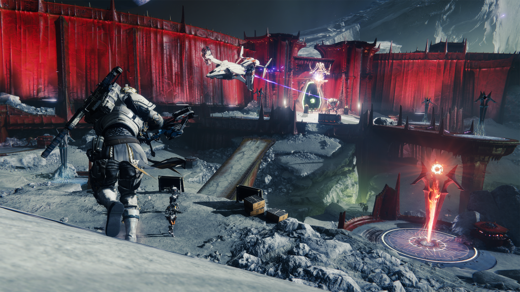 Screenshot from Destiny 2: Shadowkeep. Three guardians run towards the battlements of a blood red keep with Hive enemies defending the gate.