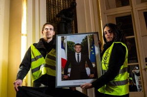 ​Climate protesters Félix Vève​, left, and Emma Chevallier with the portrait of Emmanuel Macron. Photo courtesy of Clément Tissot​