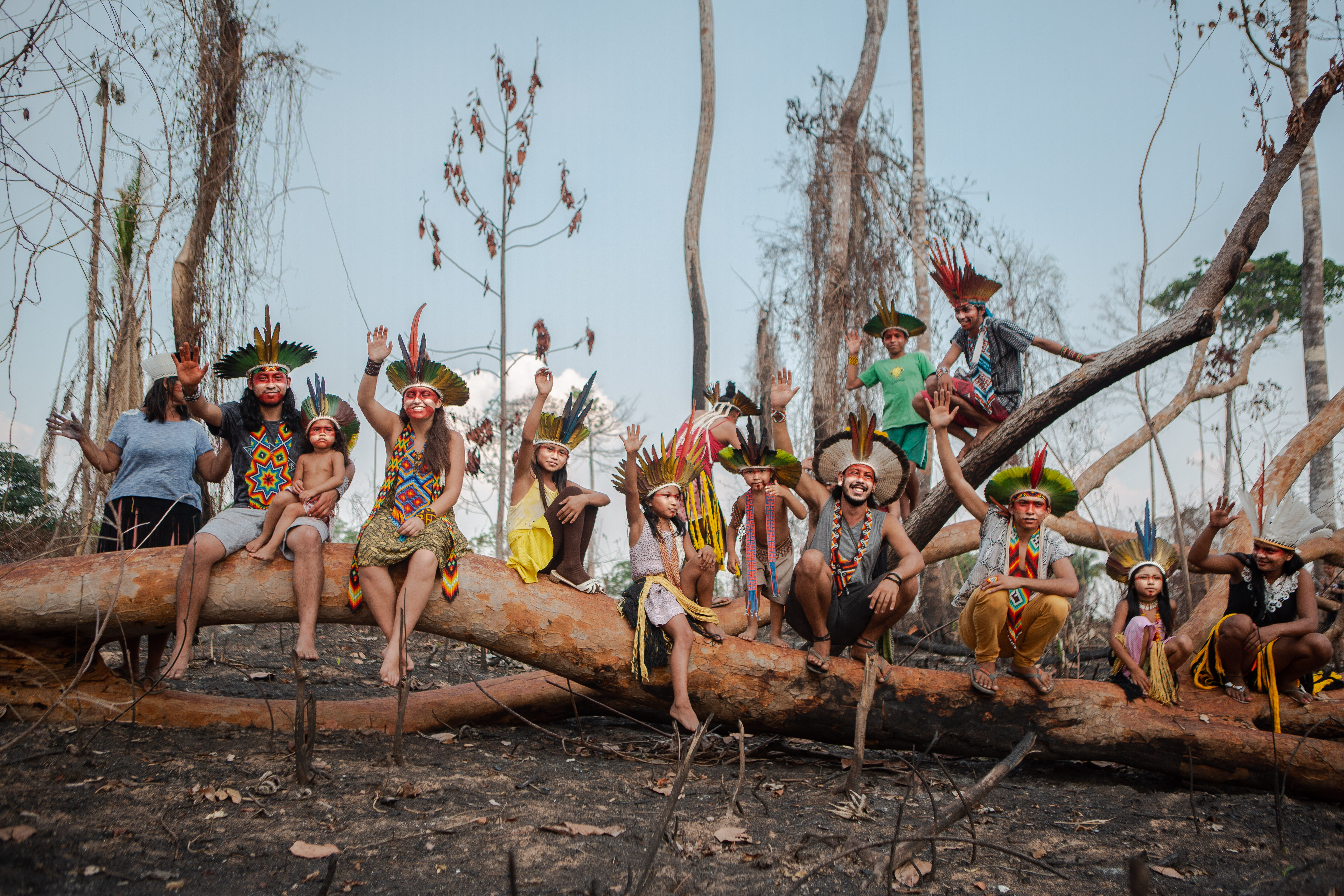 Indigenous tribe sitting on a fallen tree