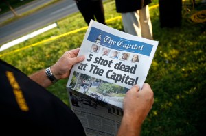 Steve Schuh, county executive of Anne Arundel County, holds a copy of The Capital Gazette near the scene of a shooting at the newspaper's office, Friday, June 29, 2018, in Annapolis, Md.