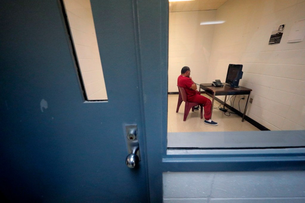 A detainee sits in a room to use a telephone inside the Winn Correctional Center in Winnfield, La., Thursday, Sept. 26, 2019. (AP Photo/Gerald Herbert)​