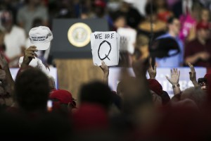 An attendee holds signs with the words "We Are Q" before the start of a rally with U.S. President Donald Trump in Lewis Center, Ohio, U.S., on Saturday, Aug. 4, 2018.