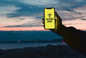 'I Miss My Pre-Internet Brain' slogan on phone screen by Douglas Coupland