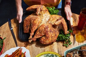 a thanksgiving dinner spread including roasted carrots and spatchcocked roasted turkey