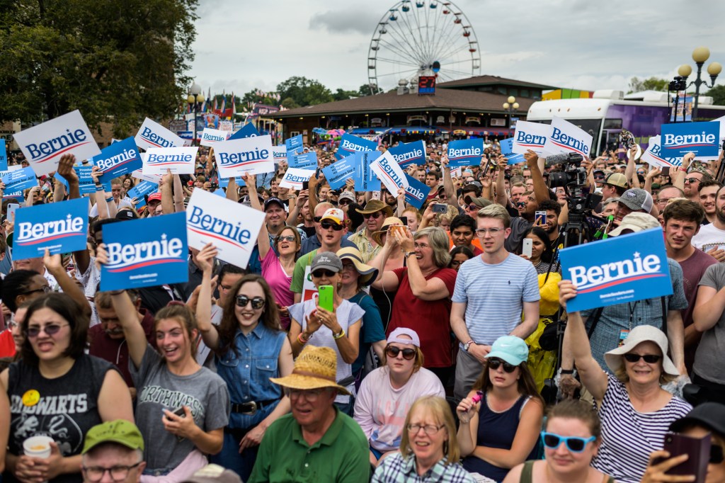 Supporters cheers as Sen. Bernie Sanders, I-Vt., 2020 Democratic Presidential Candidate, goes up on stage to speak to Iowa voters on the Soapbox stage at the Iowa State Fair on Sunday, August 11, 2019, in Des Moines, Iowa. (Photo by Salwan Georges/The Was