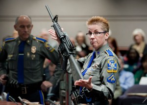 firearms training unit Detective Barbara J. Mattson, of the Connecticut State Police, holds up a Bushmaster AR-15 rifle, the same make and model of gun used by Adam Lanza in the Sandy Hook School shooting.